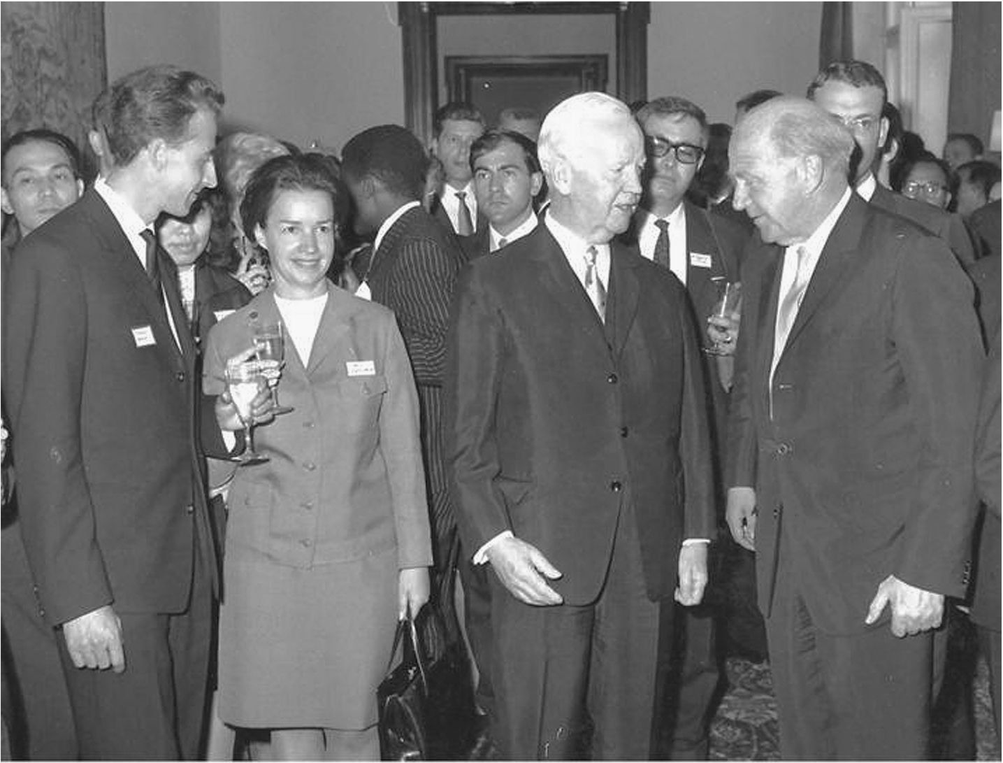 Heisenberg proudly presents his Humboldt family to the President of Germany at a reception in the German White House in Bonn in July 1966. Foreground, left to right: The author, an unknown female Humboldt Fellow, Heinrich Luebke (German President), Werner Heisenberg; Background: Other Humboldt Fellows, vintage 1966. Note that while Heisenberg and the President had dropped their champagne glasses when the photograph was taken, this inexperienced youngster is still holding on to his glass (personal photograph).