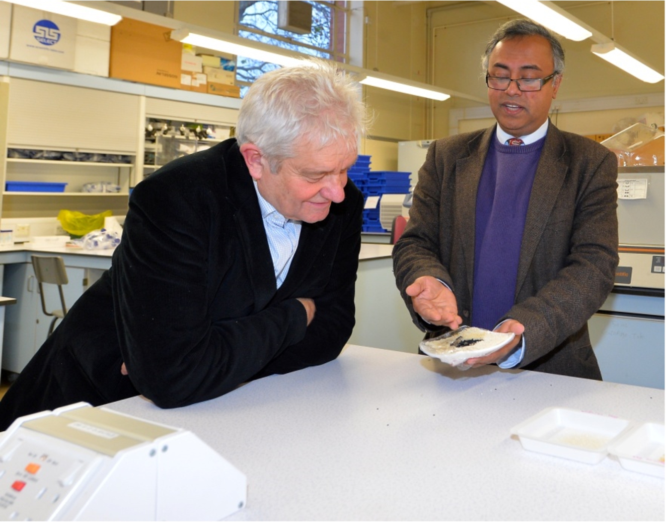 Nobel laureate, Sir Paul Nurse FRS (left), with the author of this article (6 December 2017). Sir Paul Nurse is looking at Bangladeshi aromatic rice (Kalijeera, considered to be the smallest rice in the world) and Nigella sativa seeds (known as Kalijeera in Bengali and after which the Kailjeera variety of Bangladeshi aromatic rice is named). Sir Paul Nurse officially opened the Laboratory of Biomedical and Environmental Health Research which carries out interdisciplinary research with spectroscopic techniques playing a central role. Photo credit: Alex Hannam.