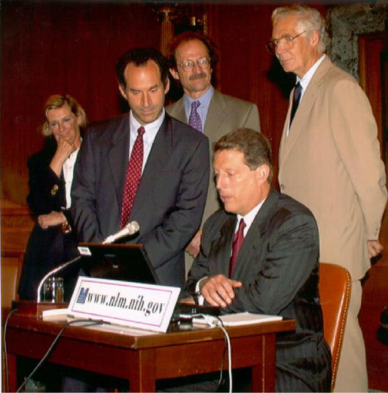 Ceremony on Capitol Hill, June, 26, 1997. On this occasion, Vice President Albert Gore (sitting) introduced free MEDLINE searching via the Internet and demonstrated a new system developed by the library called PubMed, which simplified searching for online medical information by researchers and the public alike. Standing, from left: Suzanne McInerney, David J. Lipman, MD, Director, National Center for Biotechnology Information (NCBI); Harold Varmus, MD, 1989 Nobel Laureate in Physiology or Medicine, and Director, National Institutes of Health, and NLM director Lindberg.