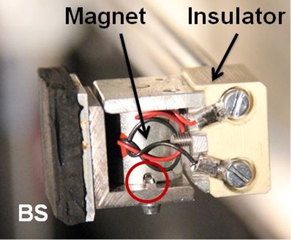 Picture of a beam stop held by the device. The circle emphasizes the indent machined on the electromagnet matching the edge of the beam stop interface for self-alignment.