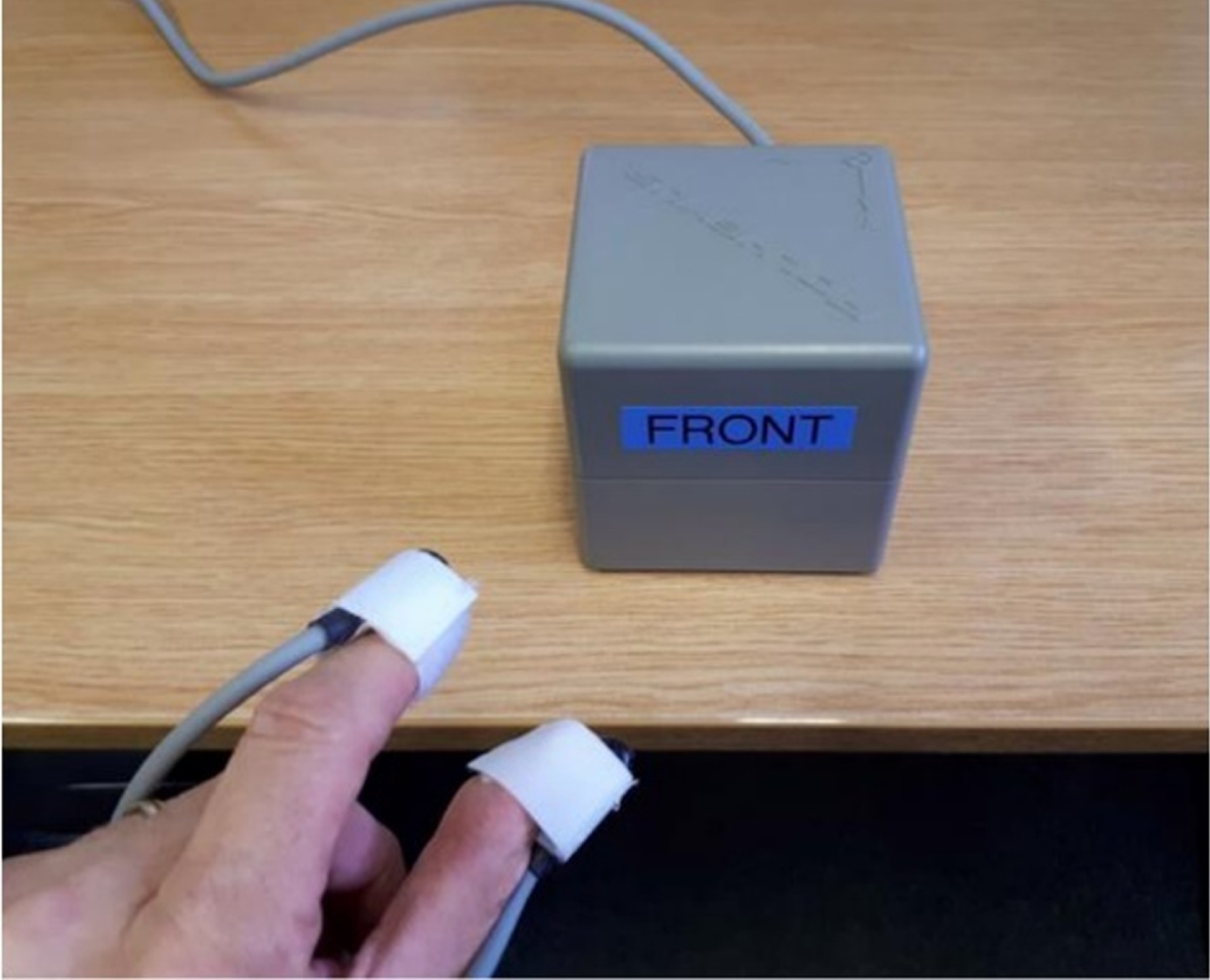 PD Monitor equipment showing electromagnetic sensors attached to participant’s thumb and forefinger that measure movements in 3D space, in relation to an electromagnetic source (box).
