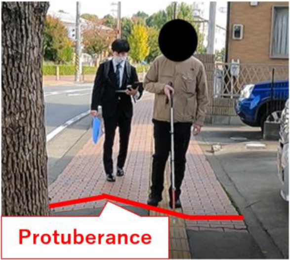 P2 perceives the protuberance of the road and adjusts the movement of the white cane movement.