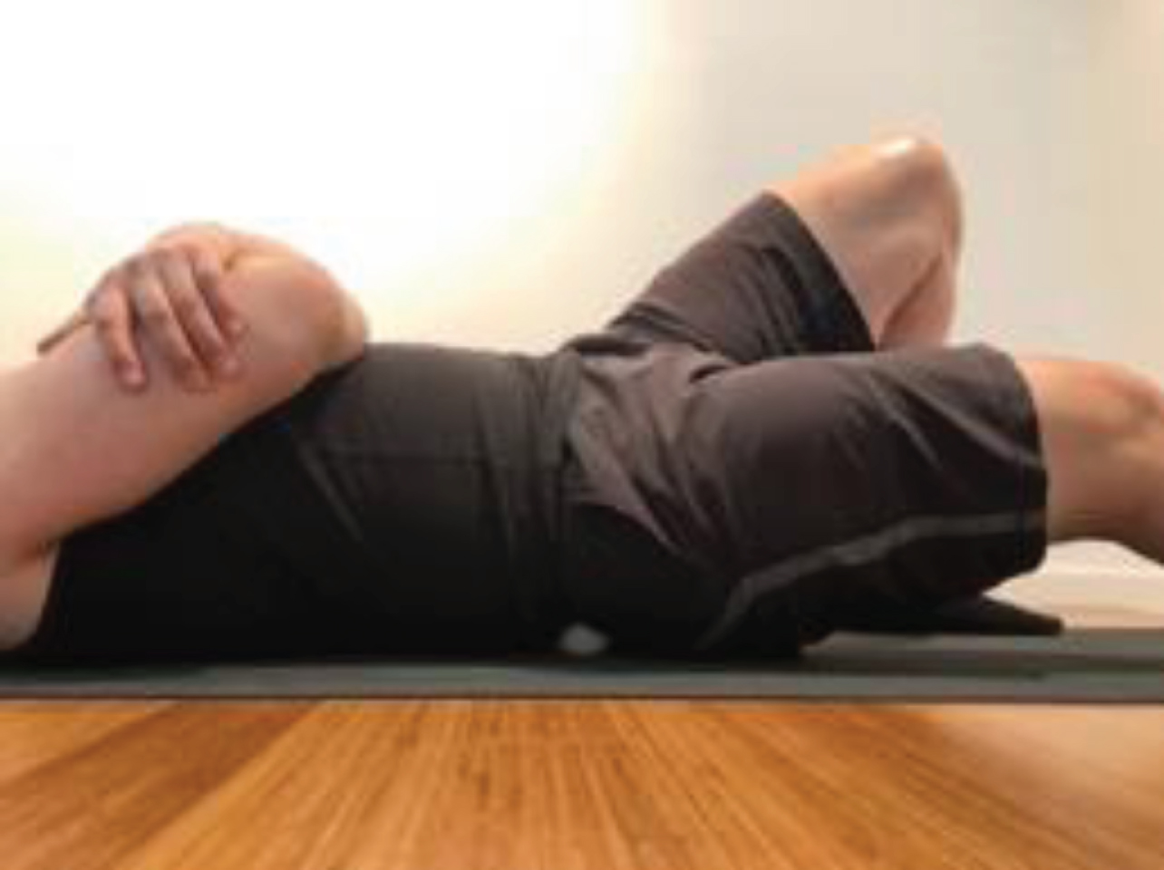 Place ball on your glutes and lie down onto your back.